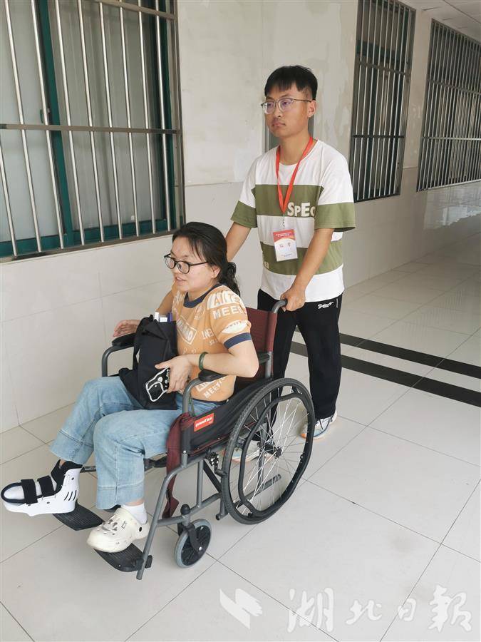 工作人员为行动不便的考生送考。 考点工作人员拍摄